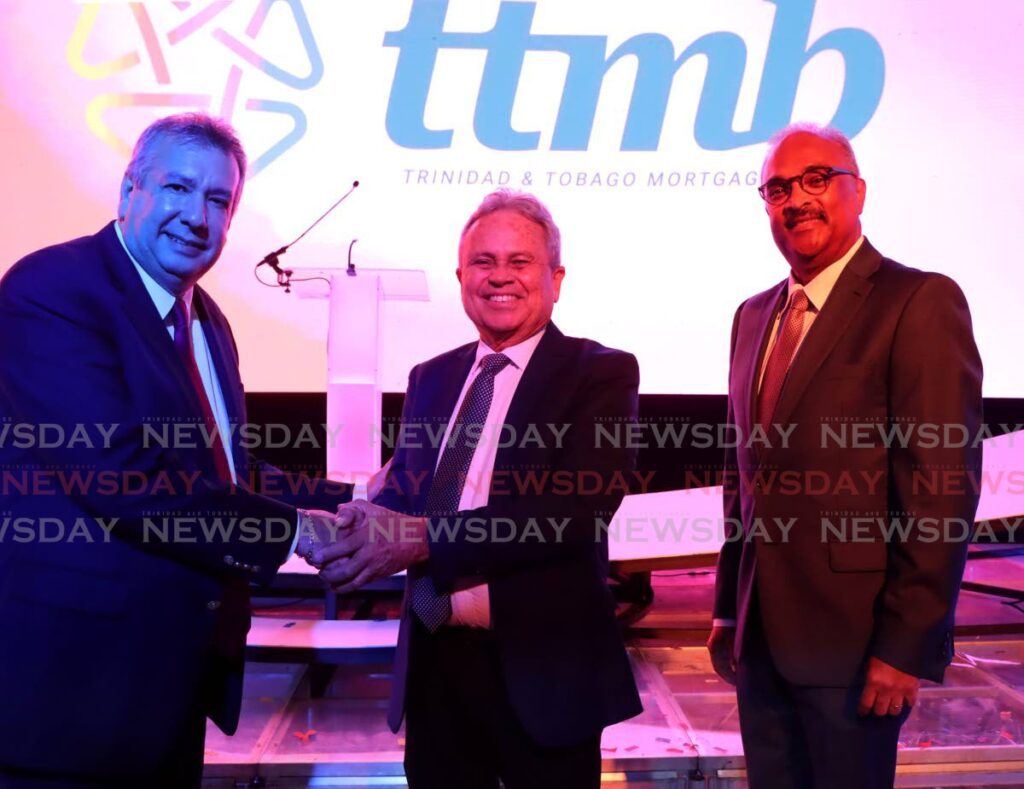 Finance Minister shakes hands with TTMB chairman Patrick Ferreira during the bank's launch at the Hyatt Regency, Port of Spain on March 20. At right is TTMB CEO Robert Green. - Photo by Ayanna Kinsale