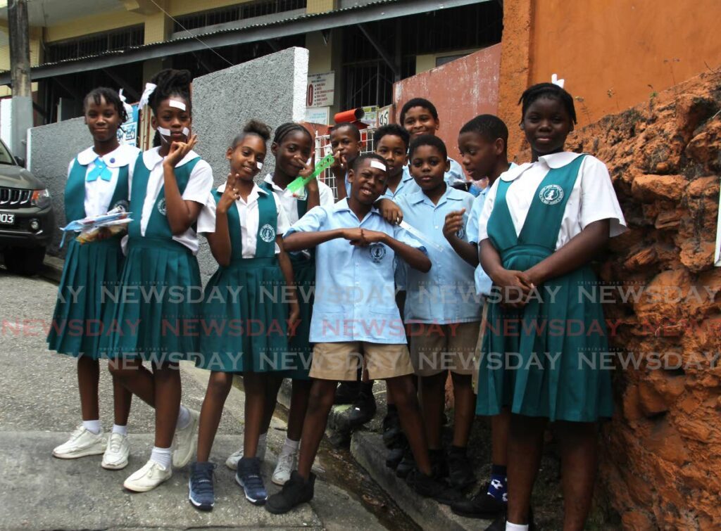 Students of Gloster Lodge Moravian School pose for photos after the Secondary School Assessment (SEA) Examination on Gloster Lodge Rd, Port of Spain March 21. - Photo by Faith Ayoung