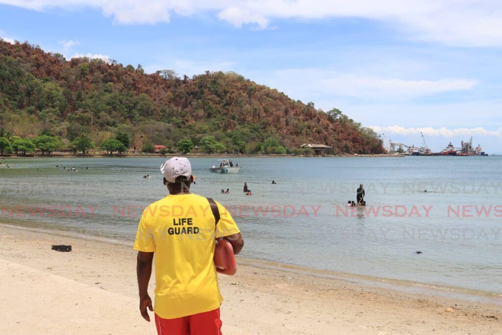 A lifeguard watches over sea bathers at Williams Bay in Chaguaramas along the western peninsula on Good Friday. - Photo by Roger Jacob
