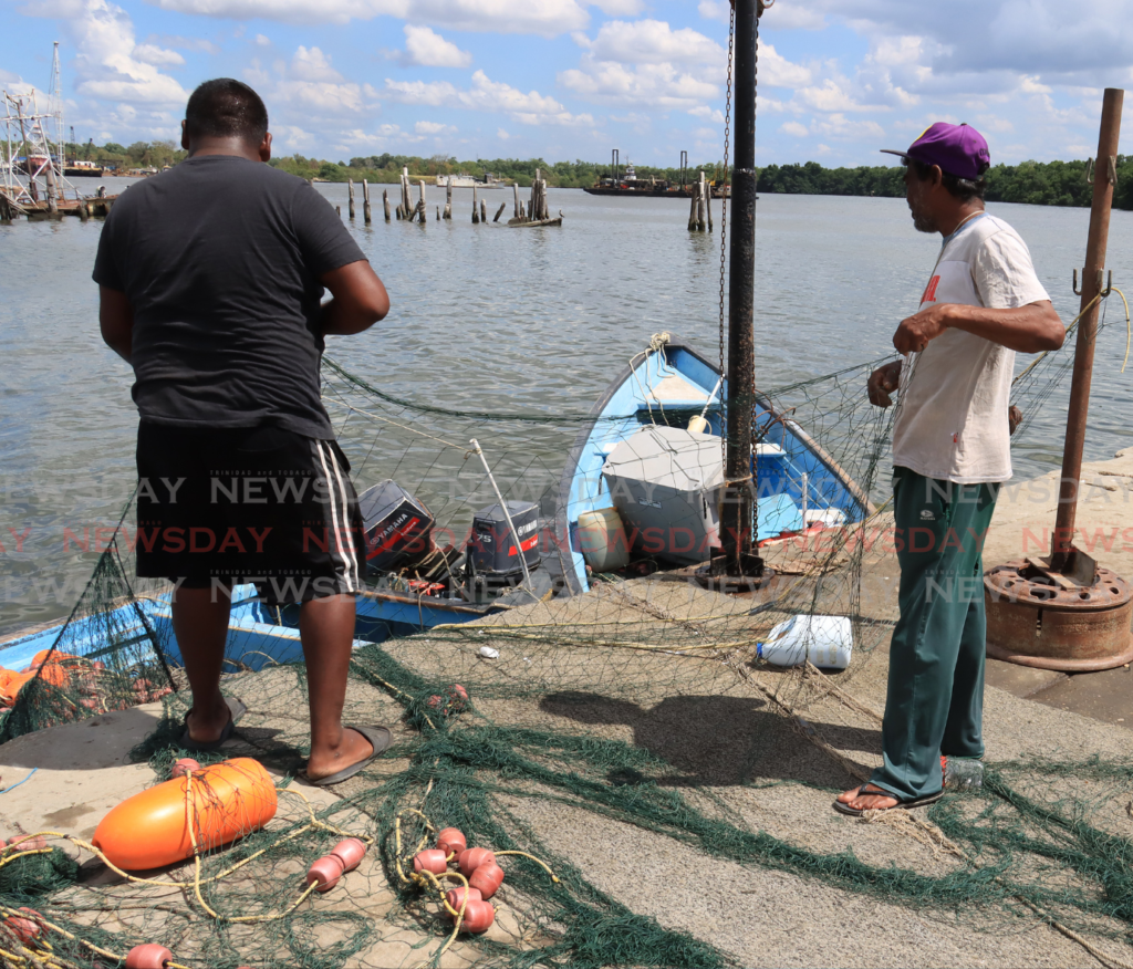 Fishermen fixed their nets ahead of an upcoming fishing expedition at the Sea Lots Fishing Village on March 4. - Photo by Roger Jacob