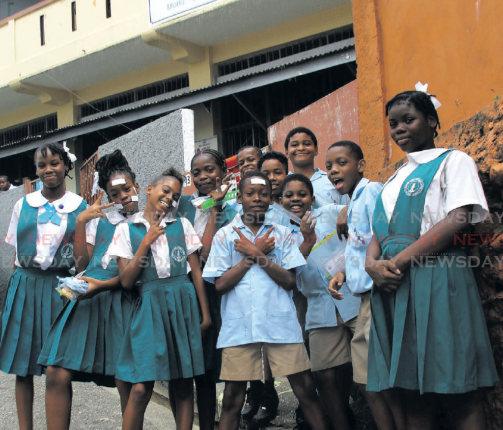 Students of Gloster Lodge Moravian Primary School pose for photos after
they sat SEA exams at the school on Gloster Lodge Rd, Port of Spain, on
Thursday. PHOTO BY FAITH AYOUNG