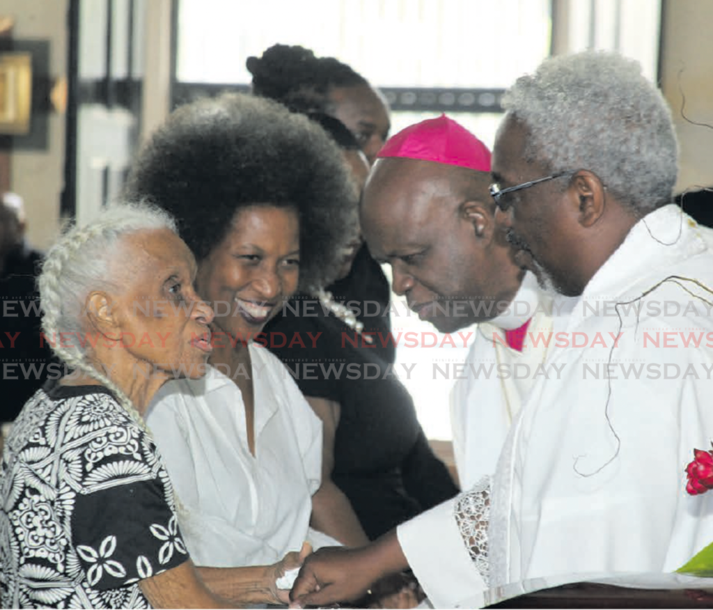 Joy Dumas, widow, and Sonja Dumas, daughter of Reginald Dumas,
are greeted by  Bishop Claude Berkley and Canon
Richard Jacob at Dumas’s funeral at the All Saints Anglican
Church, Port of Spain on Friday. PHOTO BY FAITH AYOUNG