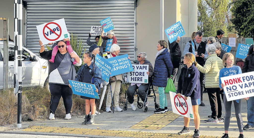 People protest outside an Auckland, New Zealand school in 2023 near where a vape shop was set to open. AP PHOTOS