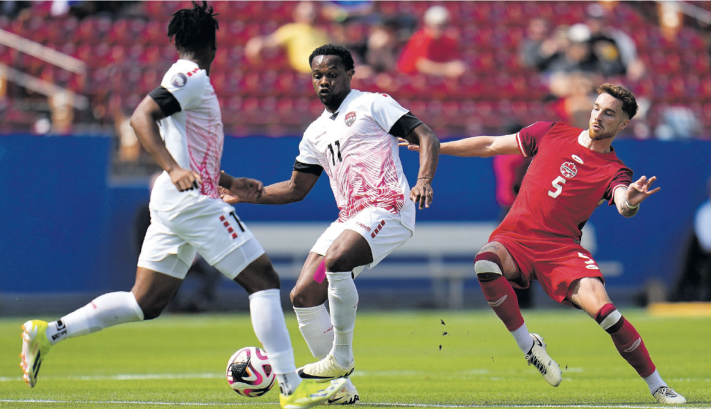 Trinidad And Tobago’s Levi Garcia, centre, makes a play with Canada’s Joel Waterman tracking closely in the first half of a Concacaf Nations
League Play-In match, on Saturday. AP PHOTO
