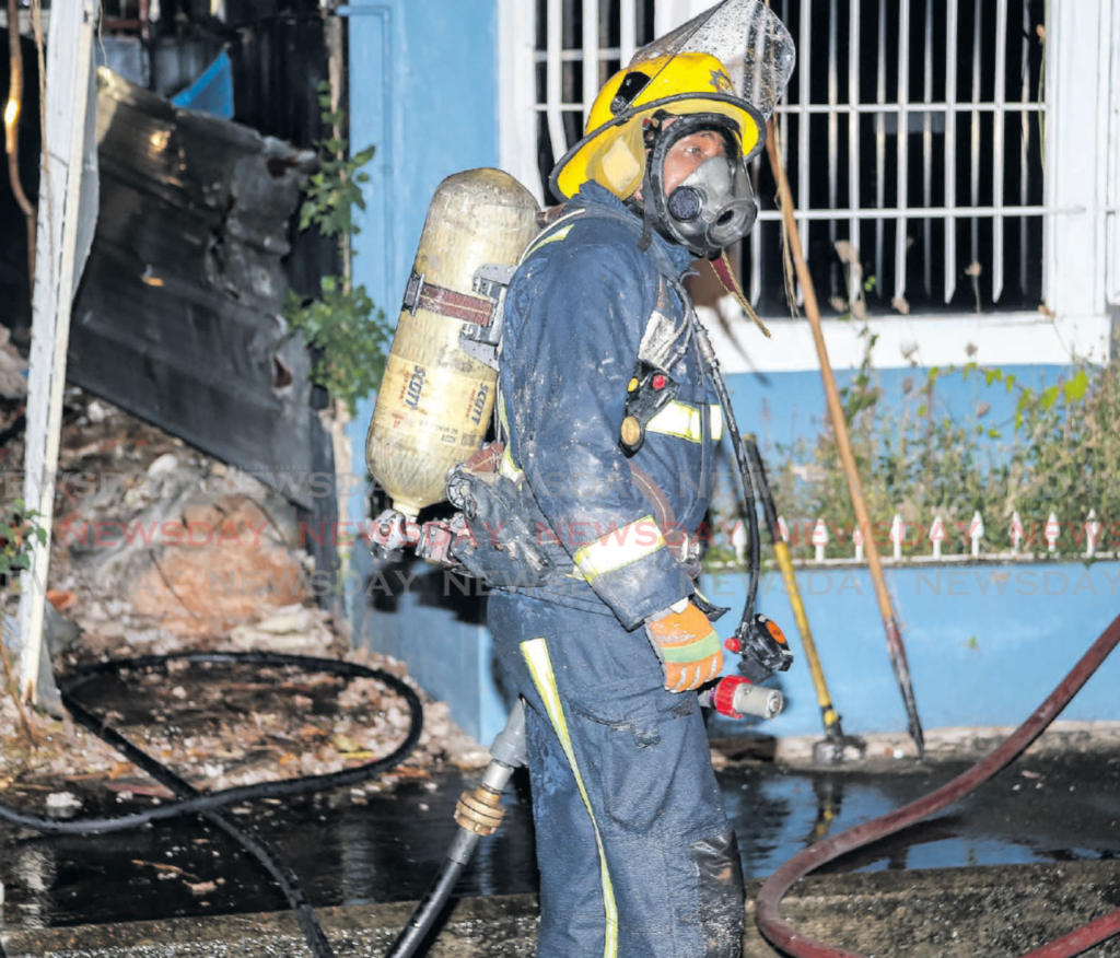IN SHORT SUPPLY: A fireman wearing a SCBA (self-contained breathing apparatus) at the scene of a fire on
Abercromby Street, Port of Spain in 2019.
The Fire Service Association claims there are less than ten such kits in the entire service. 
File Photo/Jeff Mayers