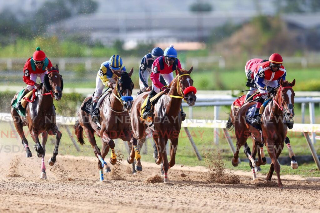 Niam Samaroo riding In The Headlines, No 4, maintains second place behind Dillon Khelawan riding Little Lady, No 3, during the first 500m of the Trinidad Derby Stakes at the Santa Rosa Park last year. - File photo by Daniel Prentice
