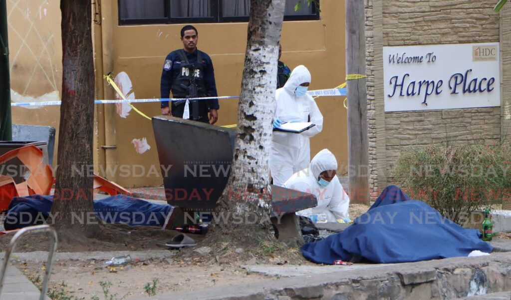 Crime scene investigators recover evidence at Harpe Place, Observatory Street, Port of Spain on March 16 where five people were killed and three injured. - File photo by Angelo Marcelle