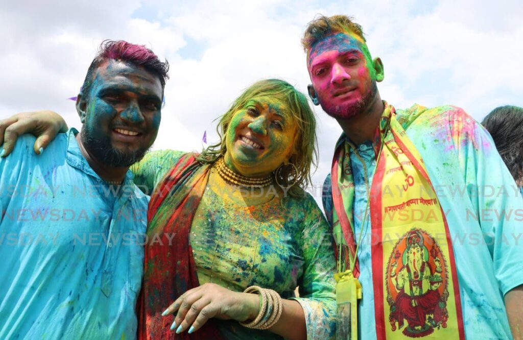 Lutchy Sonnylal, Debbie Narine and Capil Singh are covered in abeer, at Phagwa celebrations held by the National Phagwa Council of Trinidad and Tobago, Aranguez Savannah, on March 31. - Photo by Angelo Marcelle