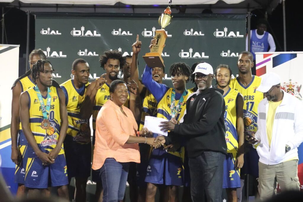 Arima MP Pennelope Beckles presents Maloney Pacers coach Christopher Jackson with the prize after his team won the Dial Basketball premier division finals on the weekend. -