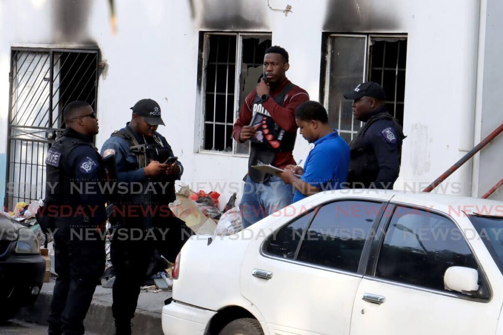 Police officers on the scene a shooting where a man was killed and another injured near the Besson Street Police Station on April 6. - Photo by Roger Jacob