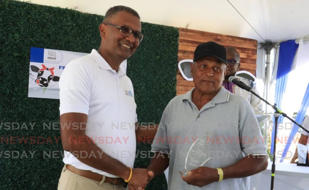 Dairy farmer Praim Singh, right, receives an award for Most Improved Farmer Quality from Nestle's business executive officer Richard Seetaram at an awards ceremony held at Nestle, Valsayn, on April 6. - Photo by Roger Jacob