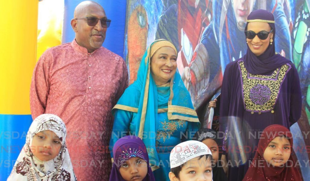 (From left) Anil Roberts, opposition senator, Kamla Persad-Bisessar, Opposition leader, and Khadijah Ameen, St Augustine MP with children of the community for Eid-ul-Fitr at the Nur-e-Islam Masjid in in El Socorro, San Juan on April 10. - Photo by Faith Ayoung