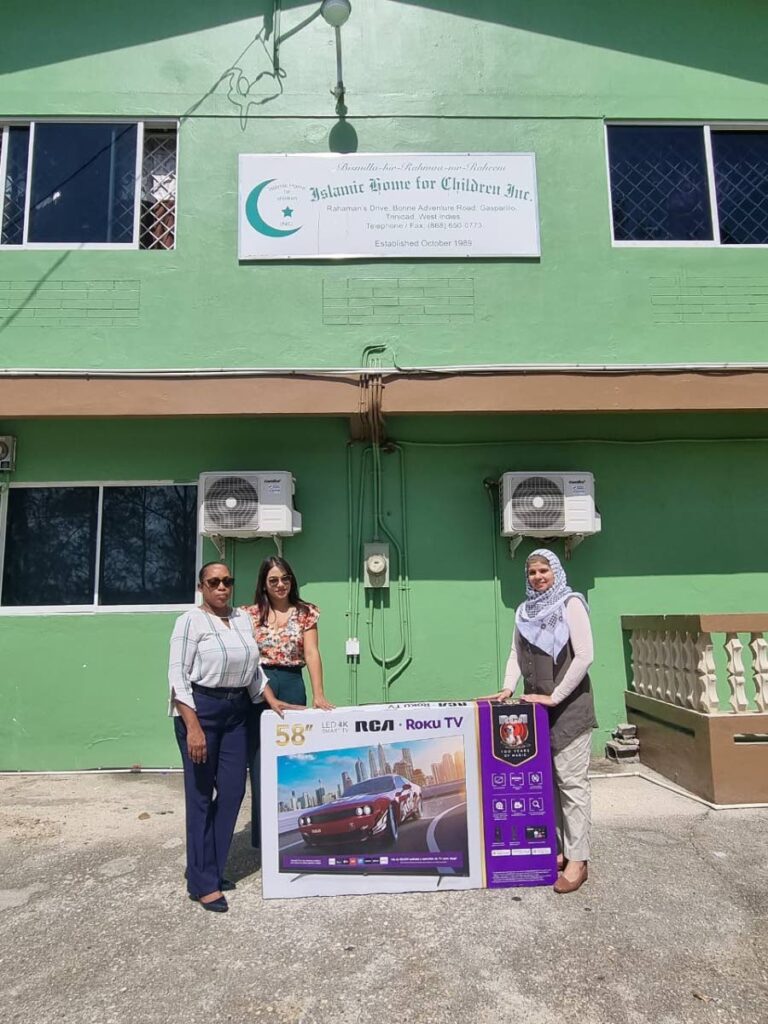 Standards Distributors Ltd area sales manager Rhonda Job, left, and digital marketing specialist Amy Heeralal, centre, present Kimberly Roberts, the manager of the Gasparillo Islamic Home for Children, with a television on April 11.  - 