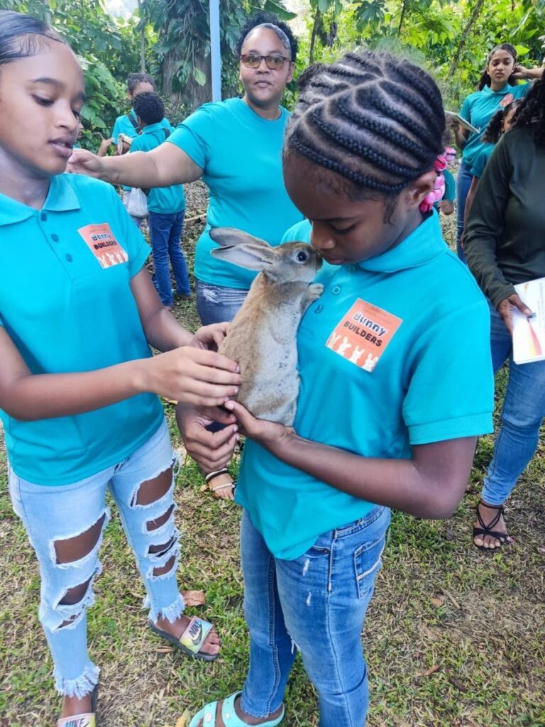 Doing what they love best! These two bunny builders care for this little bunny as their training on the caring and rearing of rabbits come to an end. - Photo courtesy Digicel Foundation