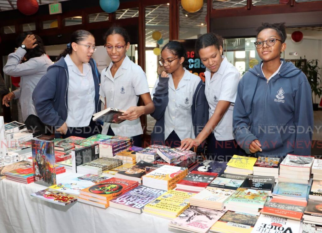 Students of St Joseph's Convent, Port of Spain check out an array of books on display at the opening of the Bocas Lit Fest, National Library, Port of Spain on April 26. - Angelo Marcelle