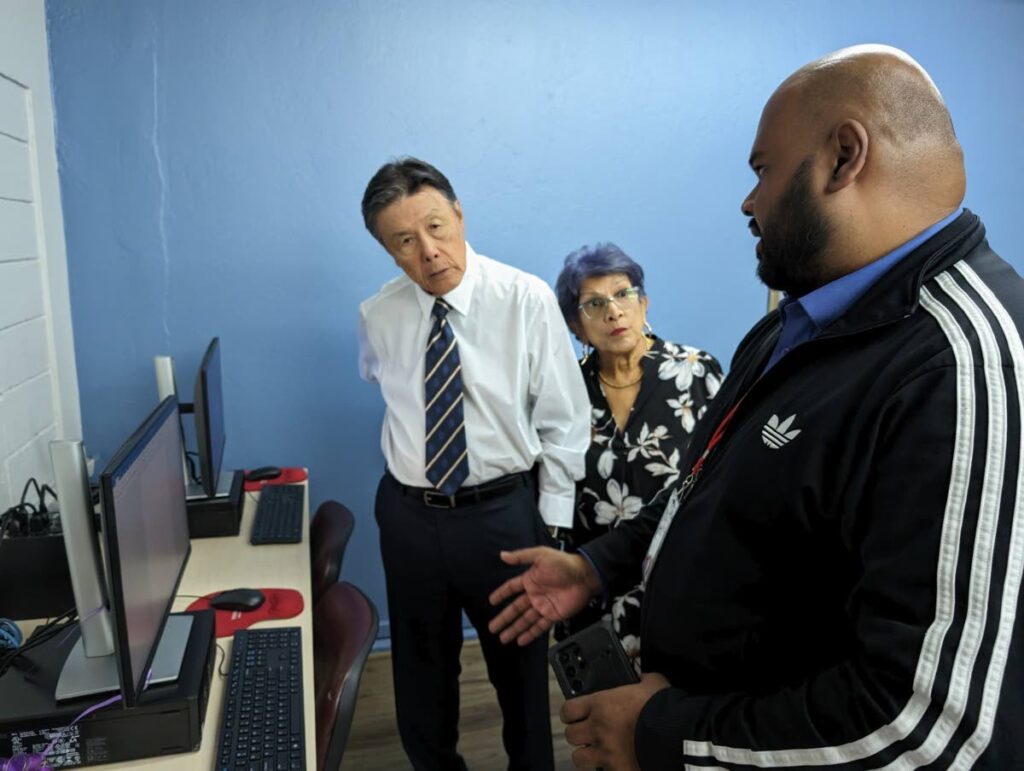 Nalis’ IT technician Rodney Gonzalez explains the software which enables visually impaired persons to access information on computers and the internet to Dr John Chin Yuen Kee and Sandra Chin Yuen Kee. - 