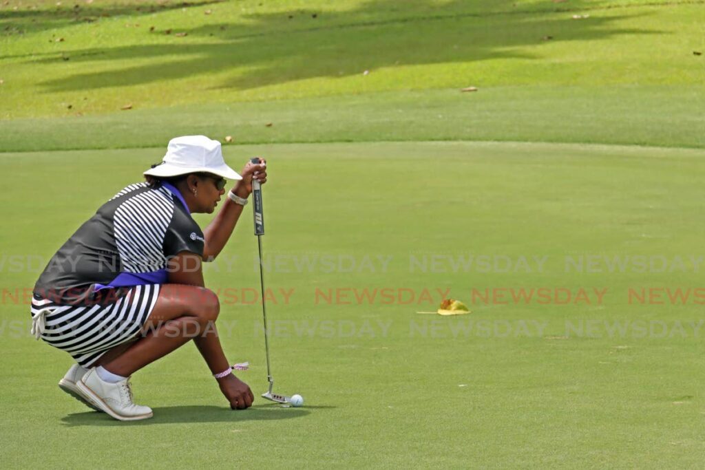A member of team Grant Thornton Orbit Solutions tries to line up a putt in the Scotiabank Charity Golf Tournament at the St Andrews Golf Club, Moka on April 26. - Photo by Venessa Mohammed
