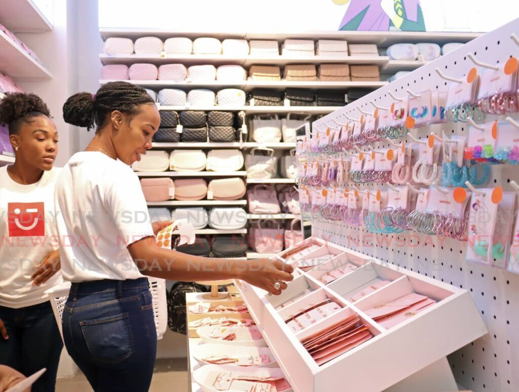 Miniso employees pricing items during the grand opening of their flagship store at the Falls at Westmall on April 26. - Photo by Venessa Mohammed
