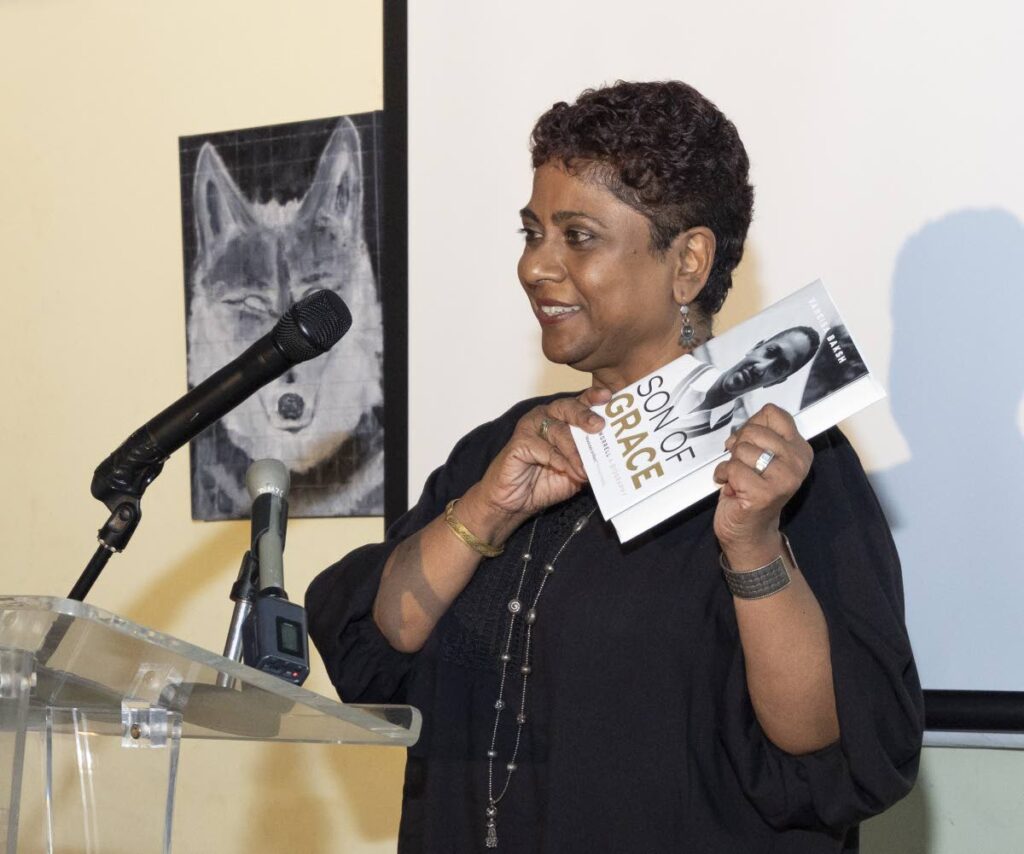 Vaneisa Baksh holds up a copy of her book at its launch on April 23 at the Dalai Llama, One Woodbrook Place, Port of Spain. - PHOTOS BY MARLON ROUSE