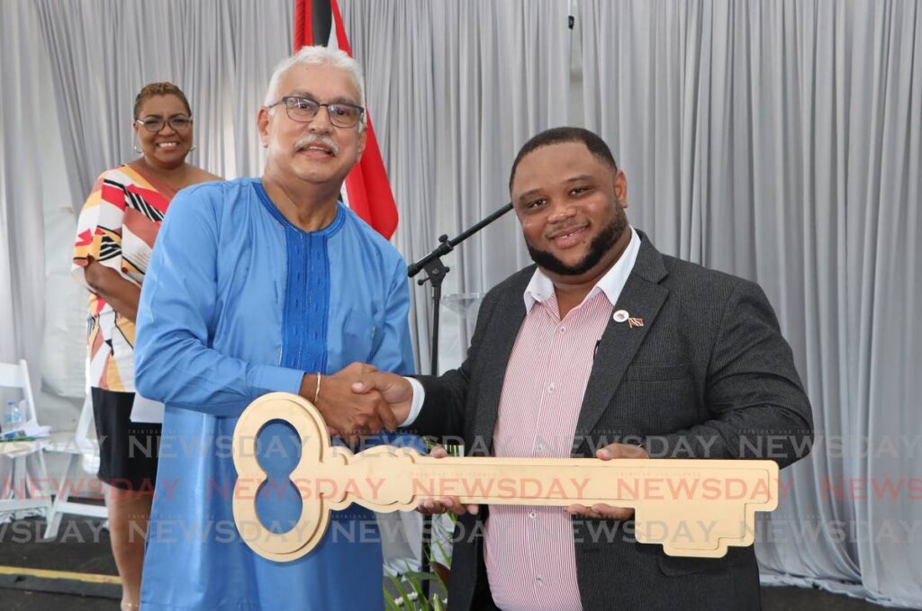 Minister of Health Terrence Deyalsingh hands over the ceremonial key for the Sangre Grande Hospital Campus to Toco/Sangre Grande MP Roger Munroe, at the commemoration ceremony at Ojoe Road on Saturday. - Angelo Marcelle