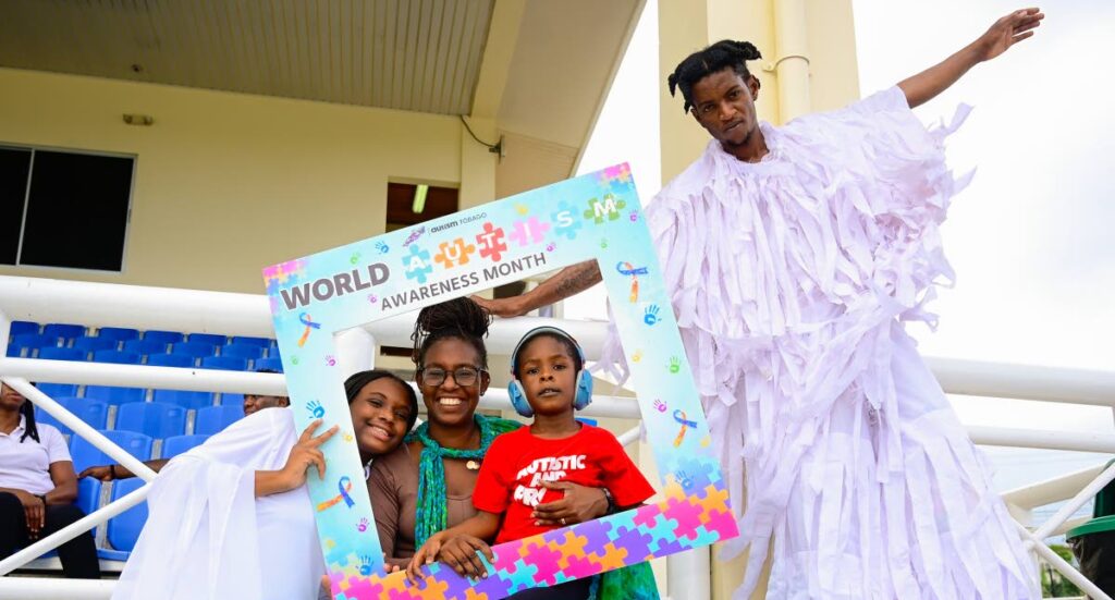 Isaiah Derrick has fun with moko jumbies at the Autism Tobago awareness fair on April 27. - Photo courtesy Visuals Style