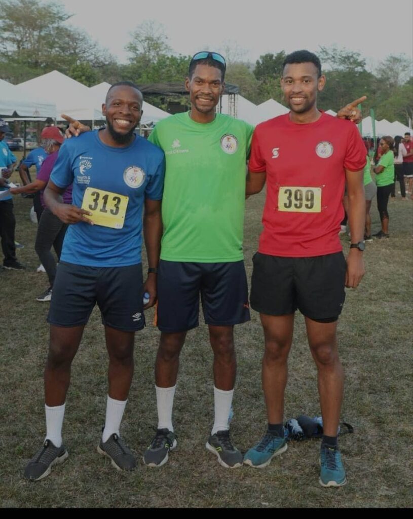 TOP THREE: Anton Robinson of First Citizens, middle, after winning the CariFin Games One-Mile Challenge at the Queen's Park Savannah. Abijah Phillip of Republic Bank, left, was second and Scotiabank's Shay Gonzales was third.  - COURTESY CARIFIN GAMES