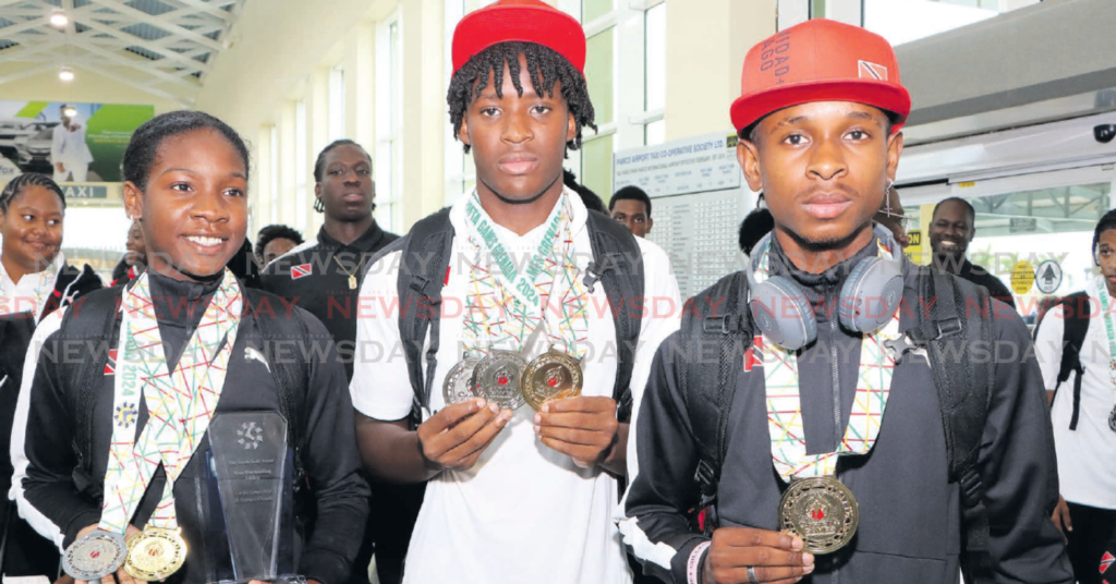 CHAMPIONS: Carifta athletes (from left) Janae De Gannes, Kadeem Chinapoo and Tafari Waldron show
their silverware at the Piarco International Airport on Tuesday. Photo by Angelo Marcelle