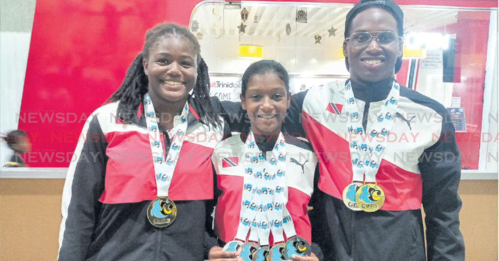 TT co-captains Amari Ash, left, and Johann-Matthew Matamoro, right, at the Piarco International Airport on
Wednesday after returning from the 37th Carifta Aquatic Championships, held in Bahamas. Marena Martinez, middle, won five medals in the girls 11-12 age group. PHOTO BY JELANI BECKLES
