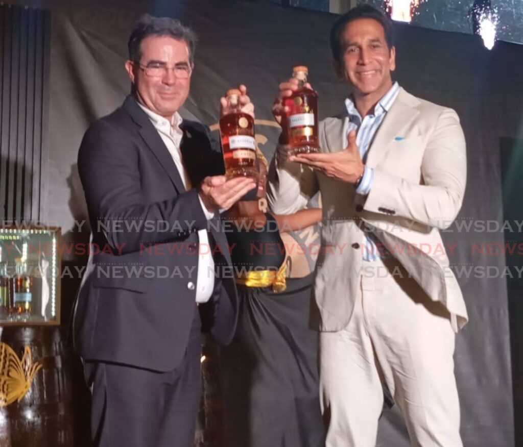 Angostura's CEO Laurent Schun, left, shows off the new bottle of the company's premium rum range with Rural Development and Local Government Minister Faris Al-Rawi. - Photo courtesy Melissa Doughty