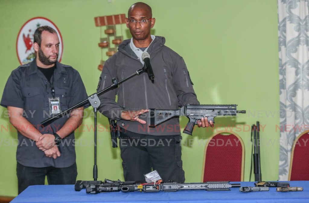 CEO 868 Tactical Firearms and Accessories holds a Grand Power Stribog SR9 A3 as he explains firearms safety and classifications in this file photo. Also in photo is law enforcement consultant Paul Nahous. - Photo by Jeff K. Mayers