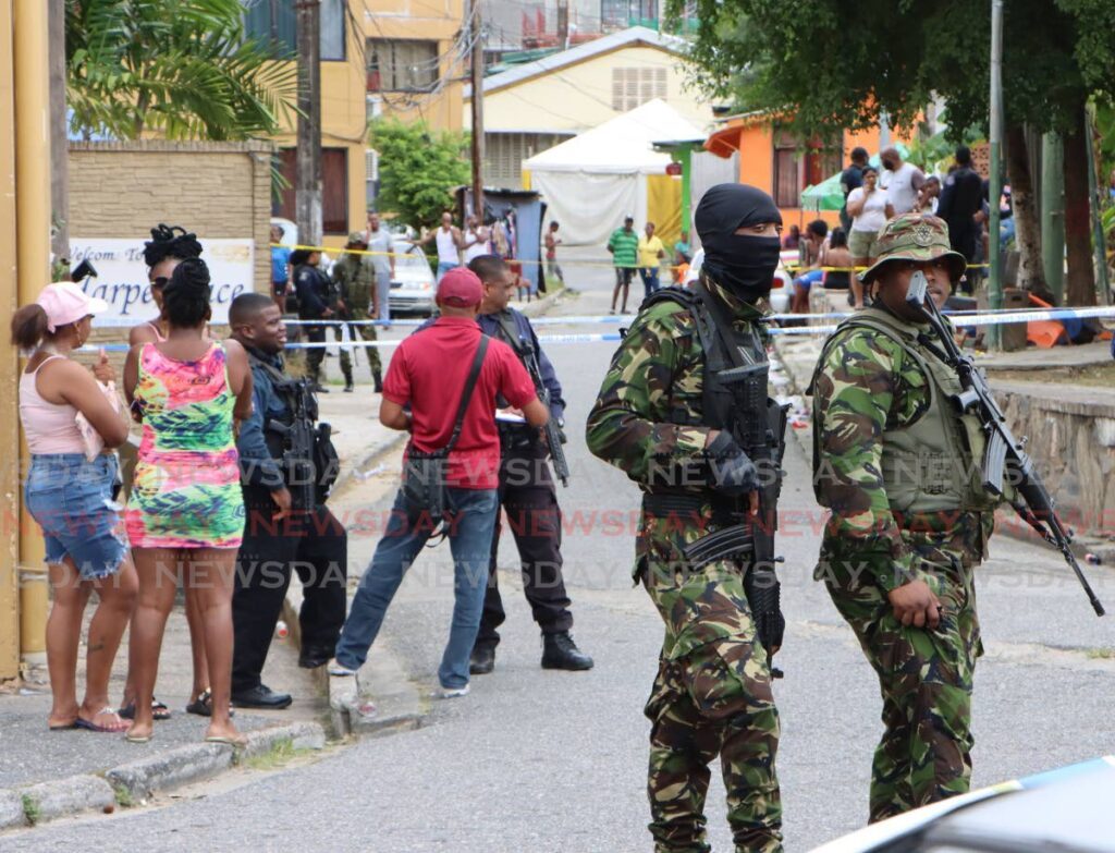 Members of the TT Defence Force keep watch on March 16 at Harpe Place, Port of Spain, after five men were killed. - Angelo Marcelle