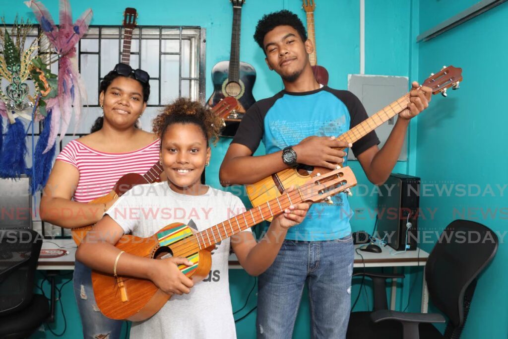 Xiomara, Xavier and Xiera are part of the La Casita of Arima music school, where they share with Venezuelan children despite not speaking Spanish. - Photo by Grevic Alvarado