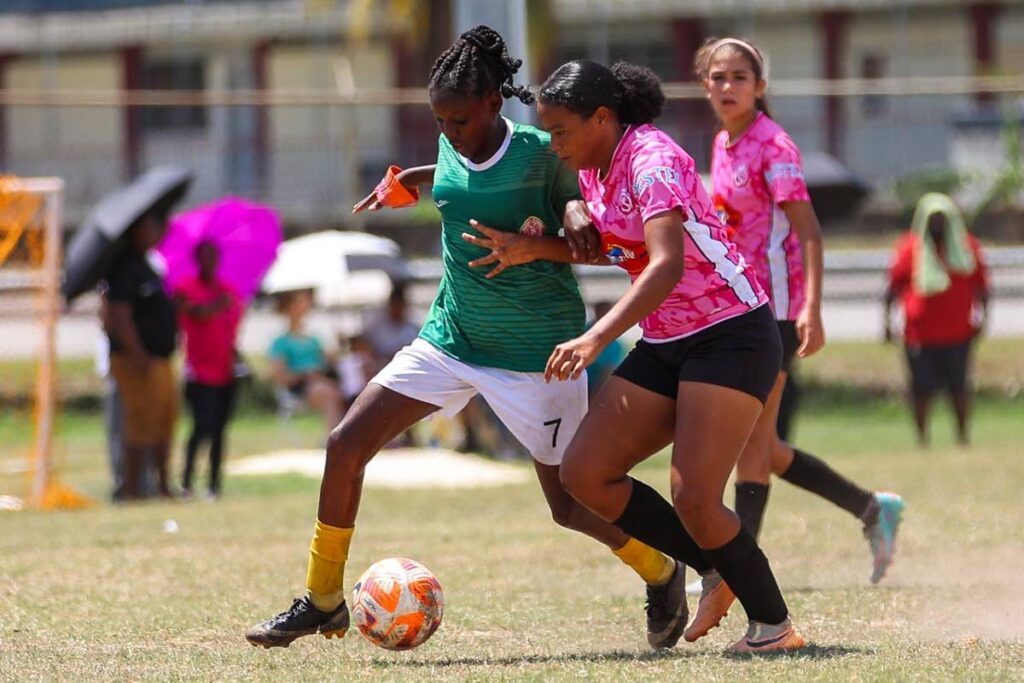 Trendsetter Hawks' under-15 captain tries to shrugg off her Pro Series opponent in a TTFA G League match at the Hasely Crawford Stadium training field, Mucurapo on April 28. Photo courtesy TTFA.  - 
