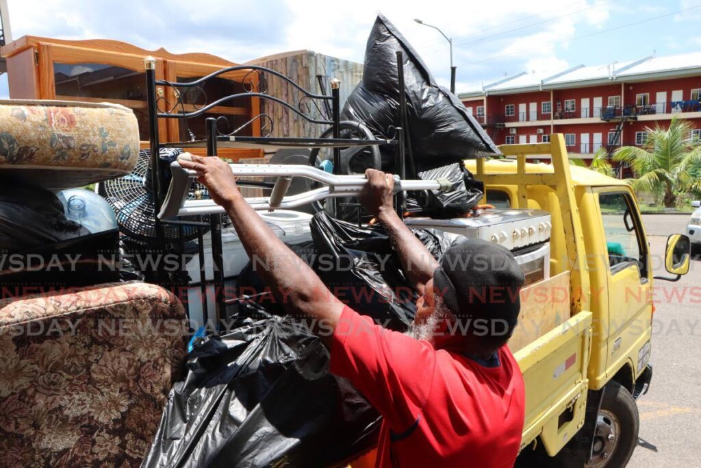 Peter Burnett packs his family's belongings on a truck, after they were evicted from their Housing Development Corporation Cyprus Hill, San Fernando, home on April 30. - Photo by Angelo Marcelle