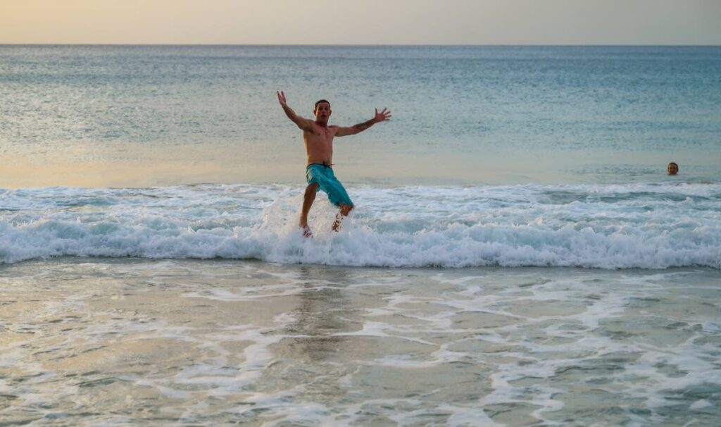 A man throws himself into the water at Store Bay on May 3, after ten beaches were reopened following the April 26 shark attack at Turtle Beach. - Photo courtesy Visuals Style 