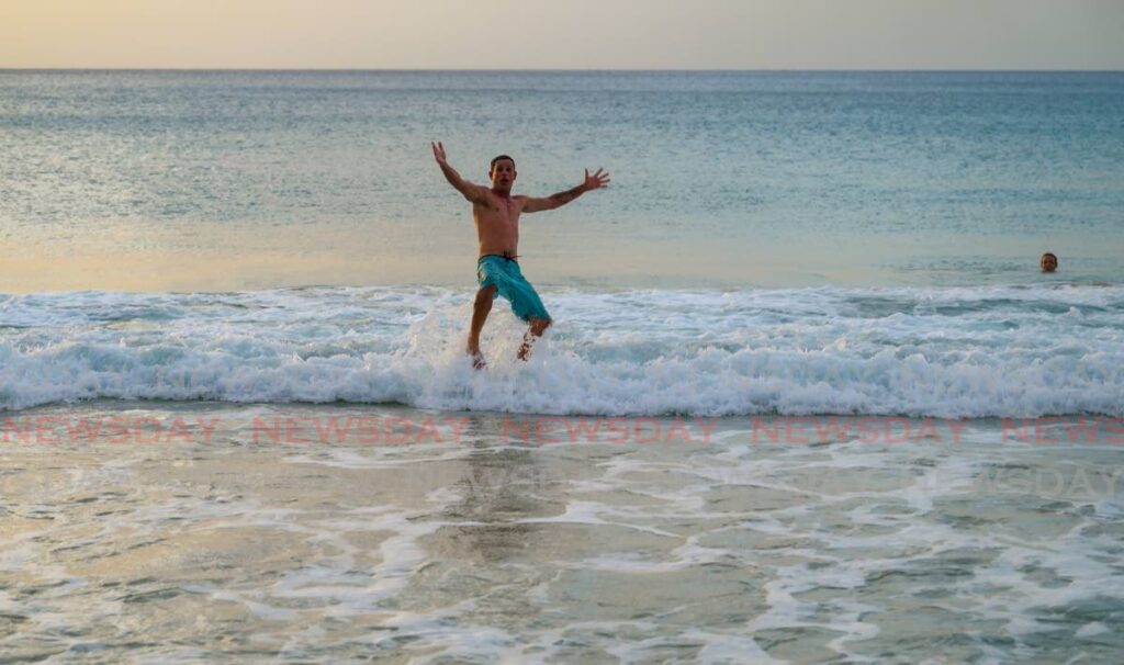 A man throws himself into the water at Store Bay on Friday, after ten beaches were reopened following the April 26 shark attack at Turtle Beach. - Visuals Style 