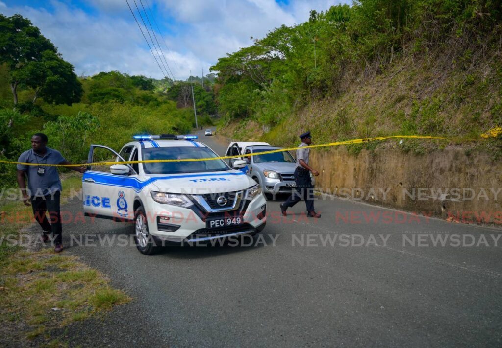 In this file photo, police cordon off the road in Mt St George, Tobago where the body of a woman was found off a precipice on May 4. - 