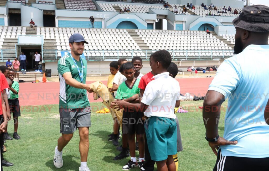 FIFA Football for Schools manager Antonio Buenano Sanchez hands out football bibs to students to separate them into teams for their age category at the start the FIFA Football for Schools Festival at Larry Gomes Stadium, Malabar, on May 7, 2024. - Faith Ayoung