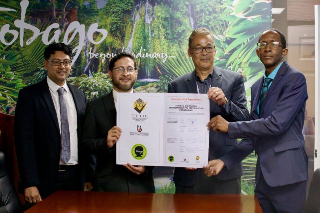 DEAL DONE: (from left) Rodney Ramnath, Manager, Certification  Division, TT Bureau of Standards; José Edwardo Trejo, Executive Director, TT Bureau of Standards; Phillip Robinson, interim CEO, Tobago Tourism Agency Ltd (TTAL); and Wendell Walker, Director Product Development and Destination Management, TTAL, hold up a certification agreement to raise the standard of Tobago's tourism stakeholders.  - Photo courtesy Tobago Tourism Agency Ltd