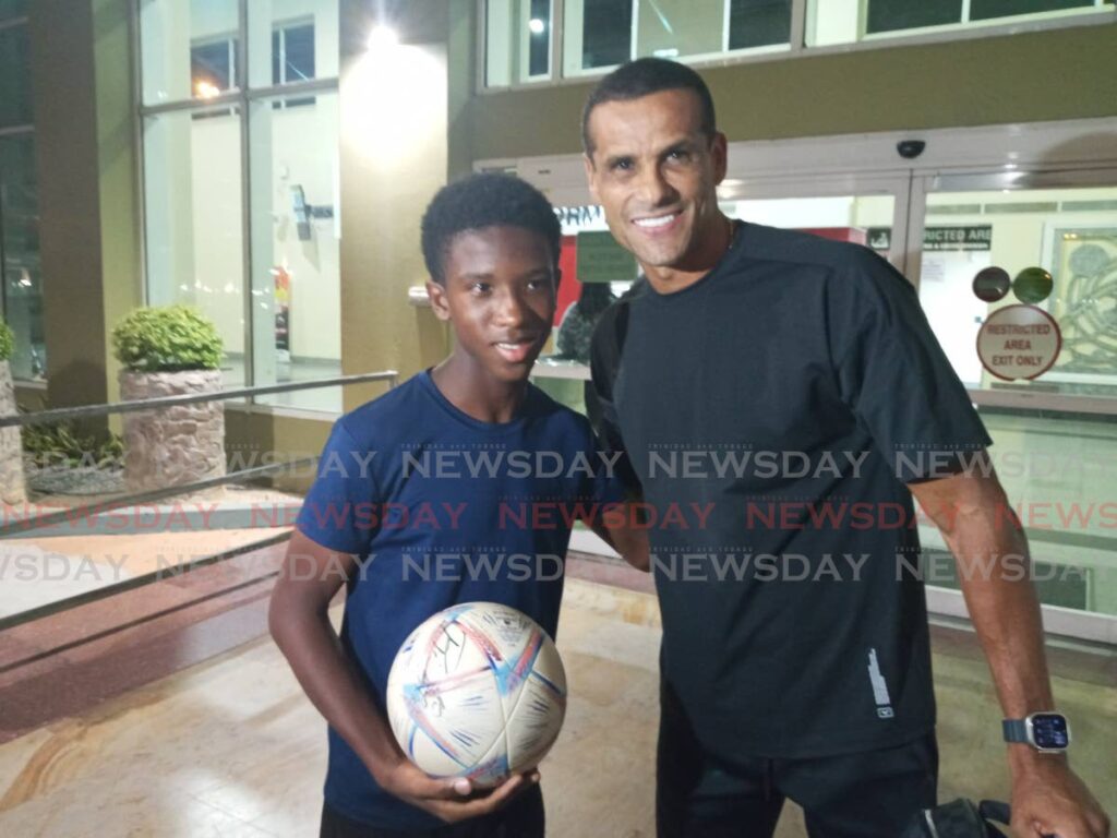 Rivaldo greets a young football fan at the Piarco International Airport on May 8. - Photo by Jelani Beckles