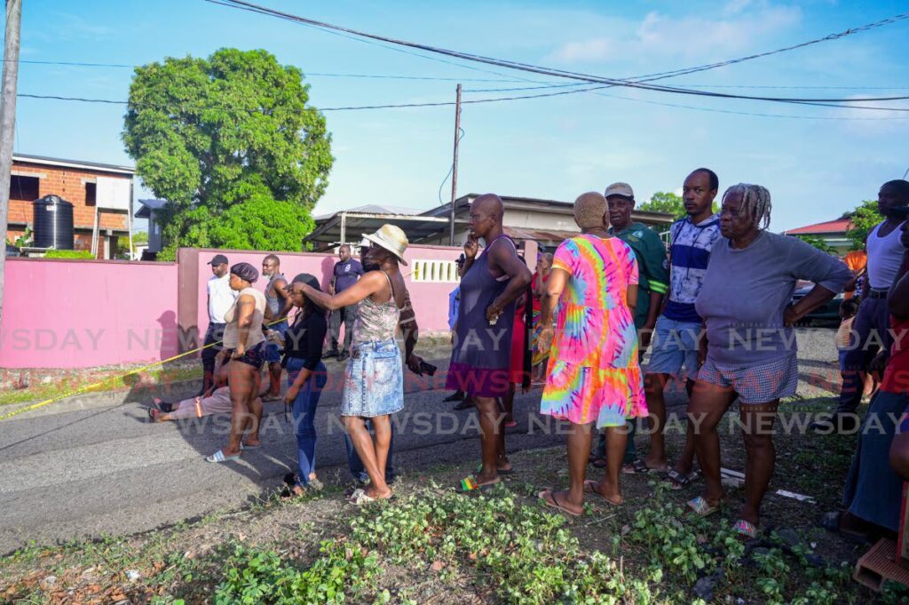 Relatives, villagers and curious onlookers behind a caution tape at Jaegers Hall Trace in Plymouth on May 9 after Nikesha Sandy, 29, was gunned down. - Photo courtesy Visuals Style 