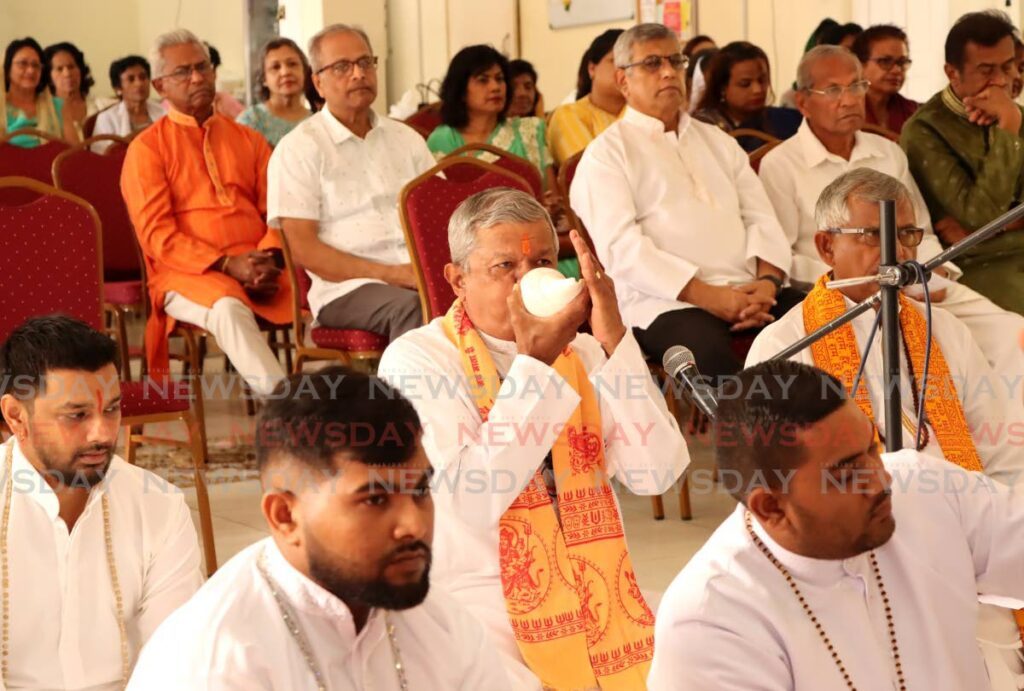 A pandit of the Pandits Parishad SDMS blows a shankh during the religious ceremony on May 13 for the purpose of atonement and restoring purity following the desecration of murtis at the temple at Watt Street, Curepe. - Photo by Ayanna Kinsale