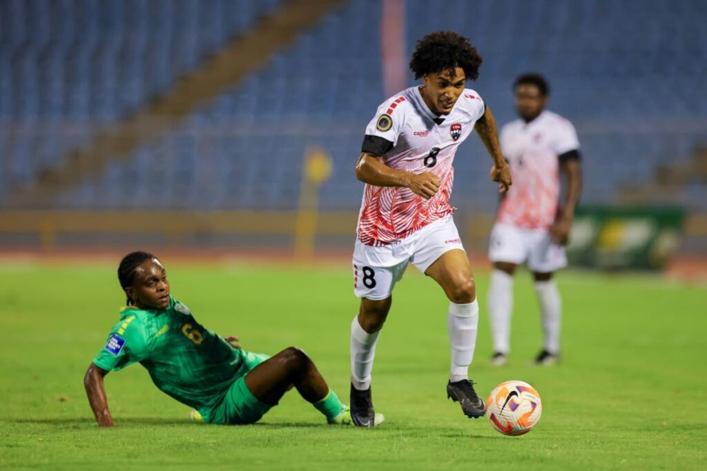 TT central midfielder Michel Poon-Angeron, right, skips past a challenge  from Guyana's Darron Niles during a friendly match at the Hasely Crawford Stadium on May 15. - Photo by Daniel Prentice