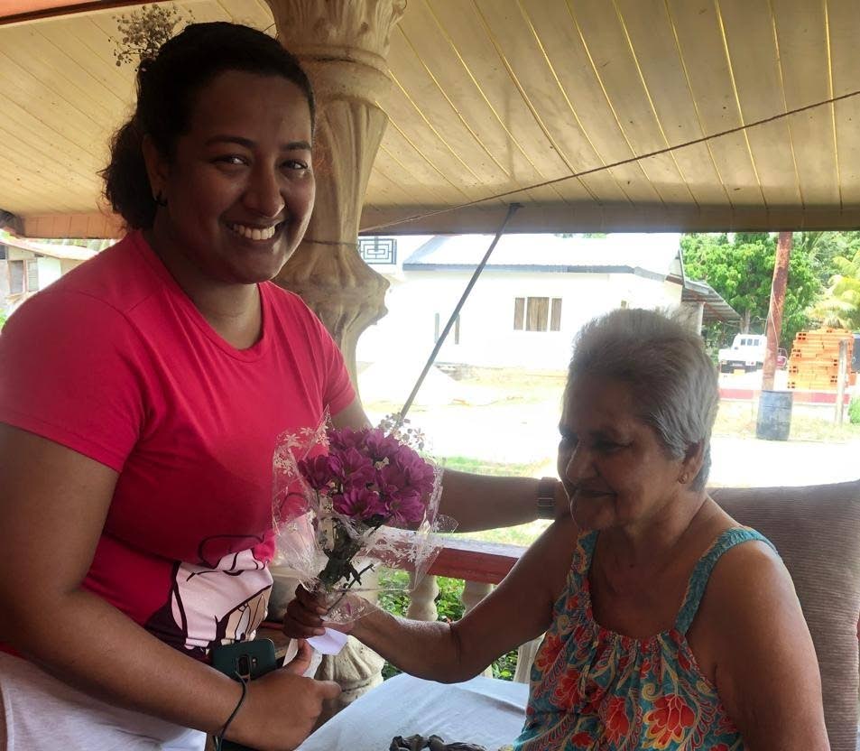 Keda Deonarine  of the Mafeking Community Council presents a bouquet to a mom. 