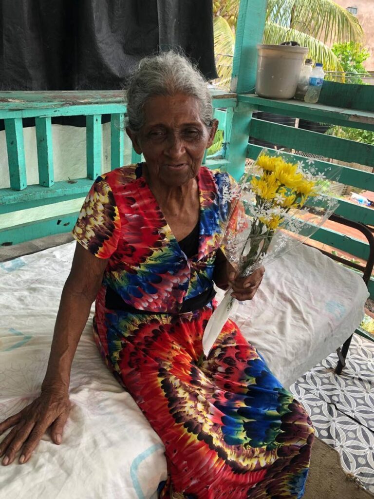 An elderly villager known affectionately as Ma King of the Mafeking community shows off her bouquet.