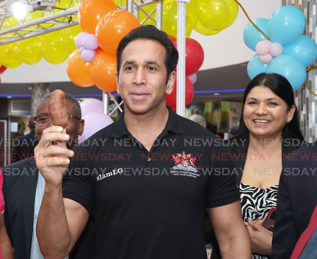 Minister of Rural Development and Local Government Faris Al-Rawi shows the media a 'stinking toe' fruit during the Food, Agriculture and Beverage Expo held at Gulf City Mall, La Romain on Friday. - Venessa Mohammed