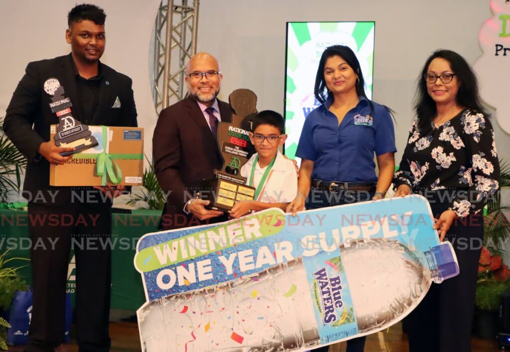 Kerwyn Garcia, husband of President Christine Kangaloo, centre, presents winner of The DATT National Primary School Diabetes quiz, Vivek Supersad-Maharaj, with a trophy at Daaga Auditorium, The UWI, St Augustine on April 17. Also in the photo, from left, are DATT president Dr Andrew Dhanoo, Keisha Maharaj of Blue Waters and Supersad-Maharaj's teacher Angenie. - AYANNA KINSALE