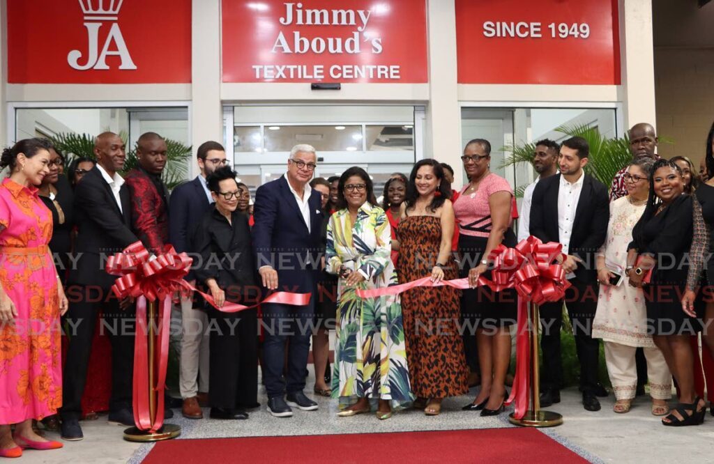 THE TEXTILE KING: Trade Minister Paula Gopee-Scoon and Gregory Aboud, centre, cut the ribbon for the new Jimmy Aboud flagship store in Barataria on May 18.  - Photo by Angelo Marcelle