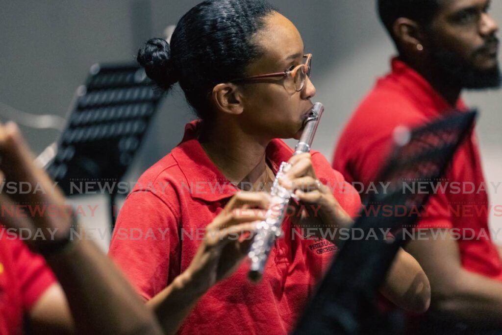 Martina Chow-Antoine, principal flautist at the National Philharmonic Orchestra, practices during an open rehersal at the National Academy of the Performing Arts on May 16. 
 - Photo by Jeff K. Mayers