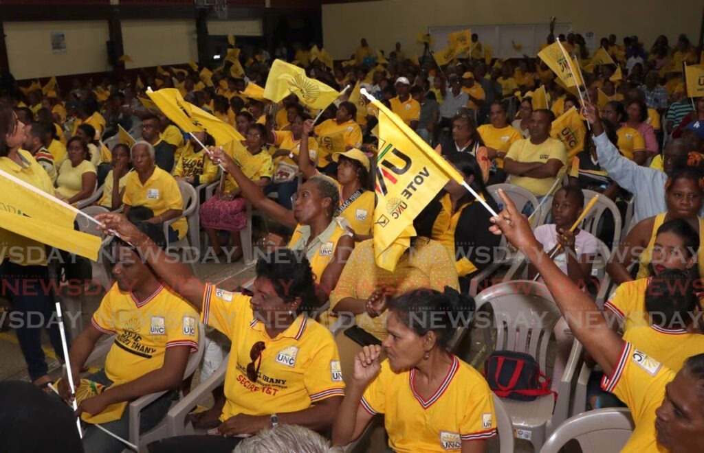UNC supporters wave flags at a cottage meeting at the Penal Secondary School on May 20. 